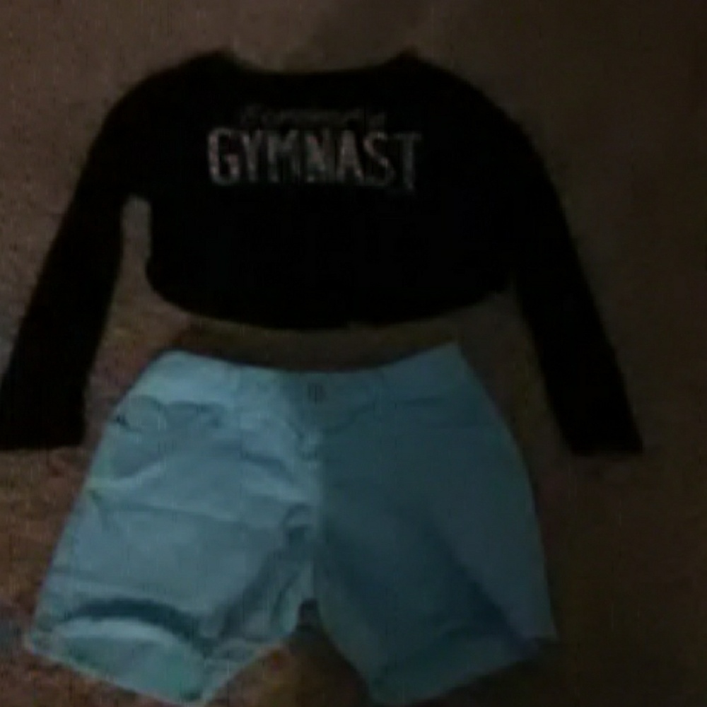 A black crop top and turquoise jean shorts